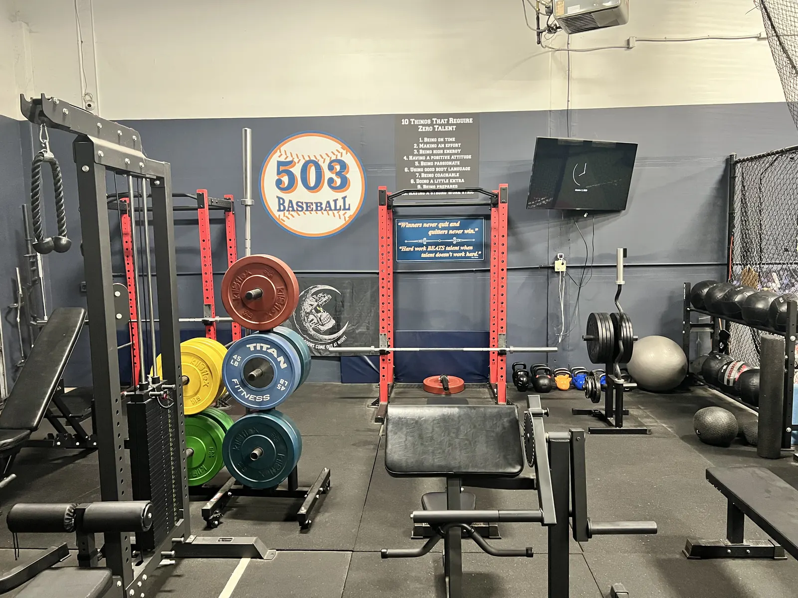 Strength training room at 503 Baseball with squat racks and free weights